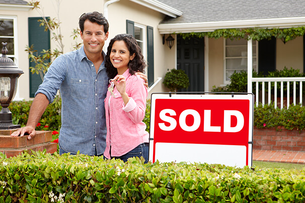 Couple in front of recently purchased house